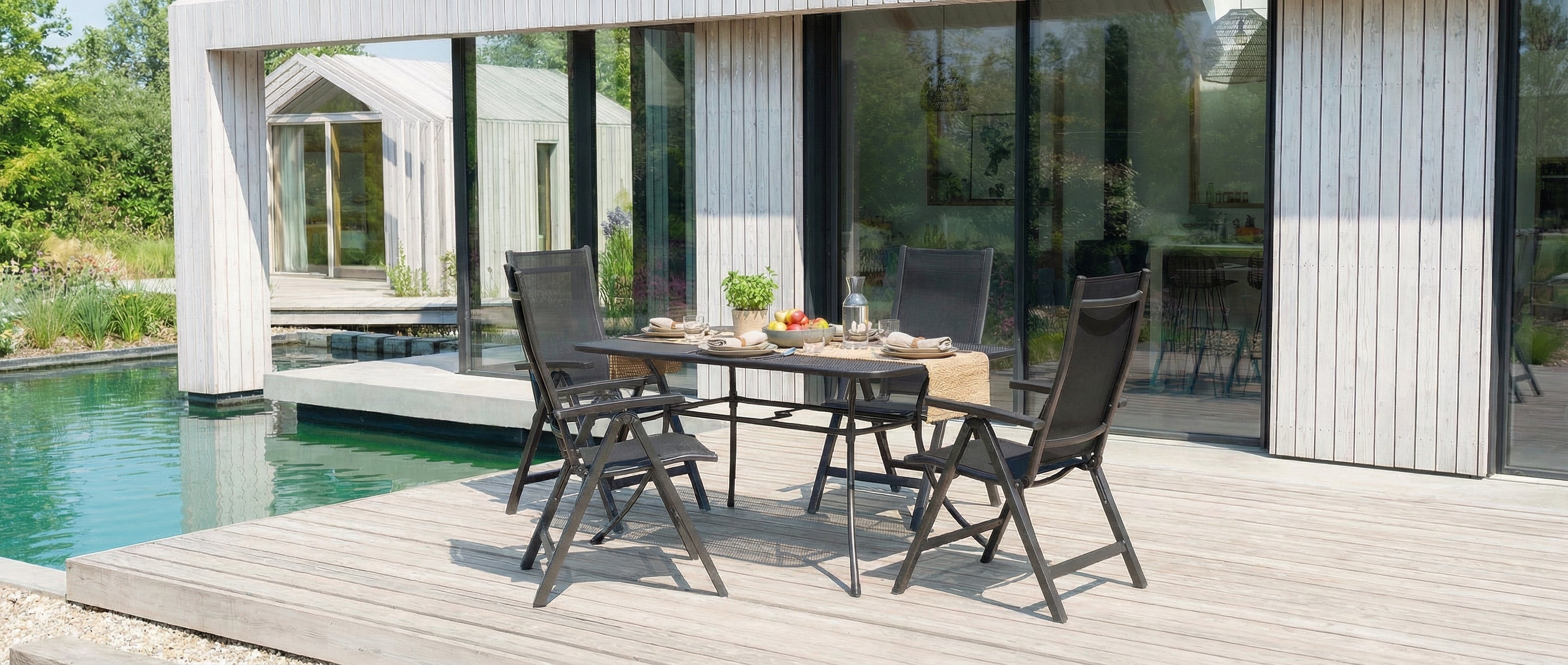 Portofino outdoor dining area with table and chairs near a poolside house.