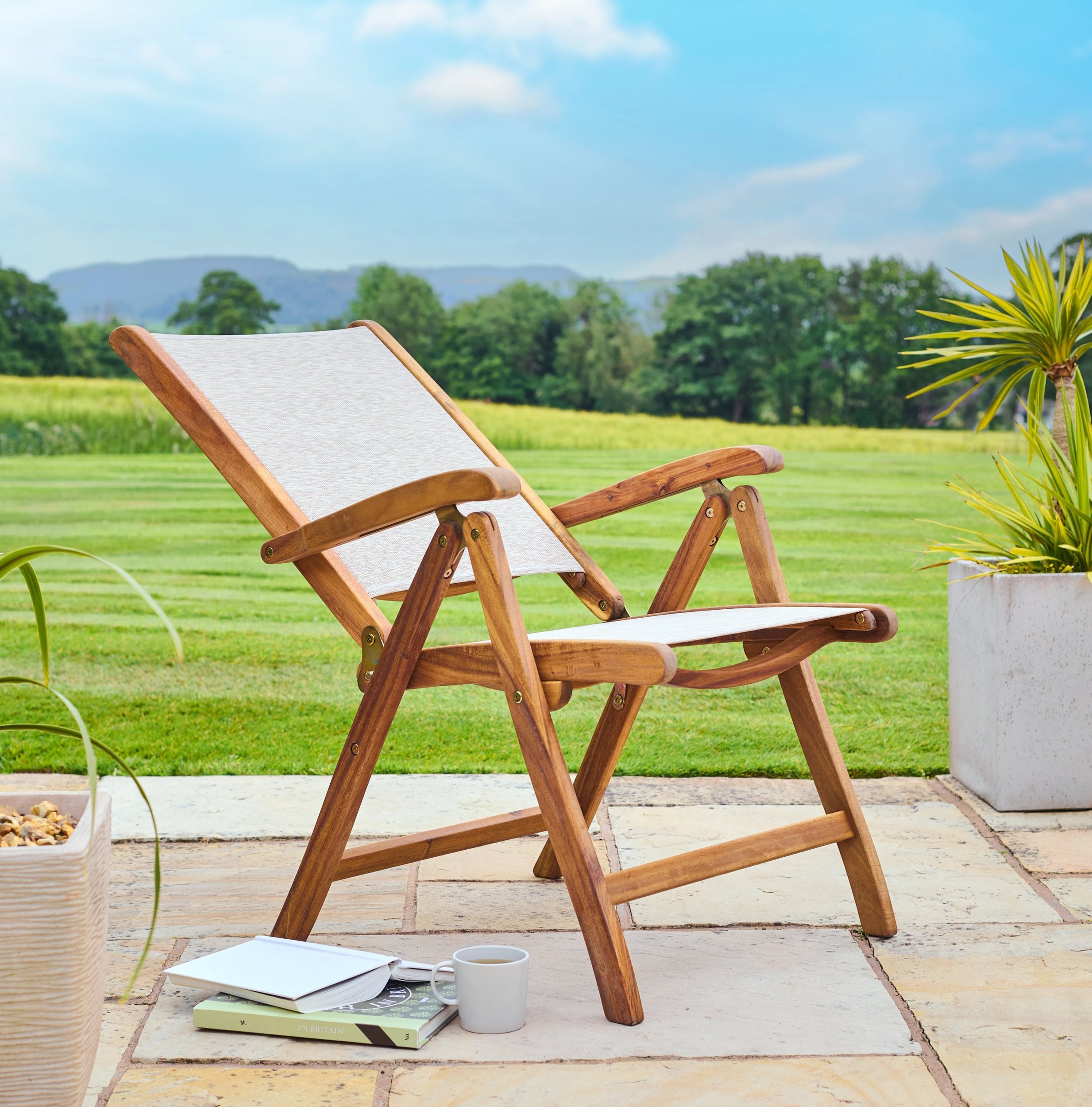 Wooden deck chair on a patio with a scenic background