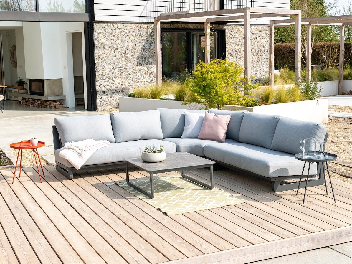 RIMINI GREY MODULAR CORNER SOFA WITH COFFEE TABLE ON A PATIO SETTING