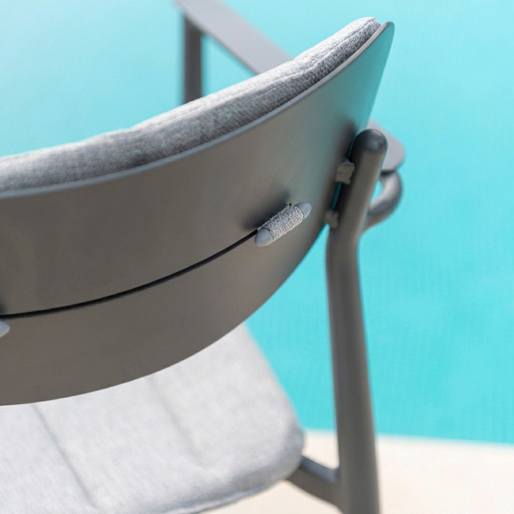 Close-up of a chair with gray cushion against a blue background