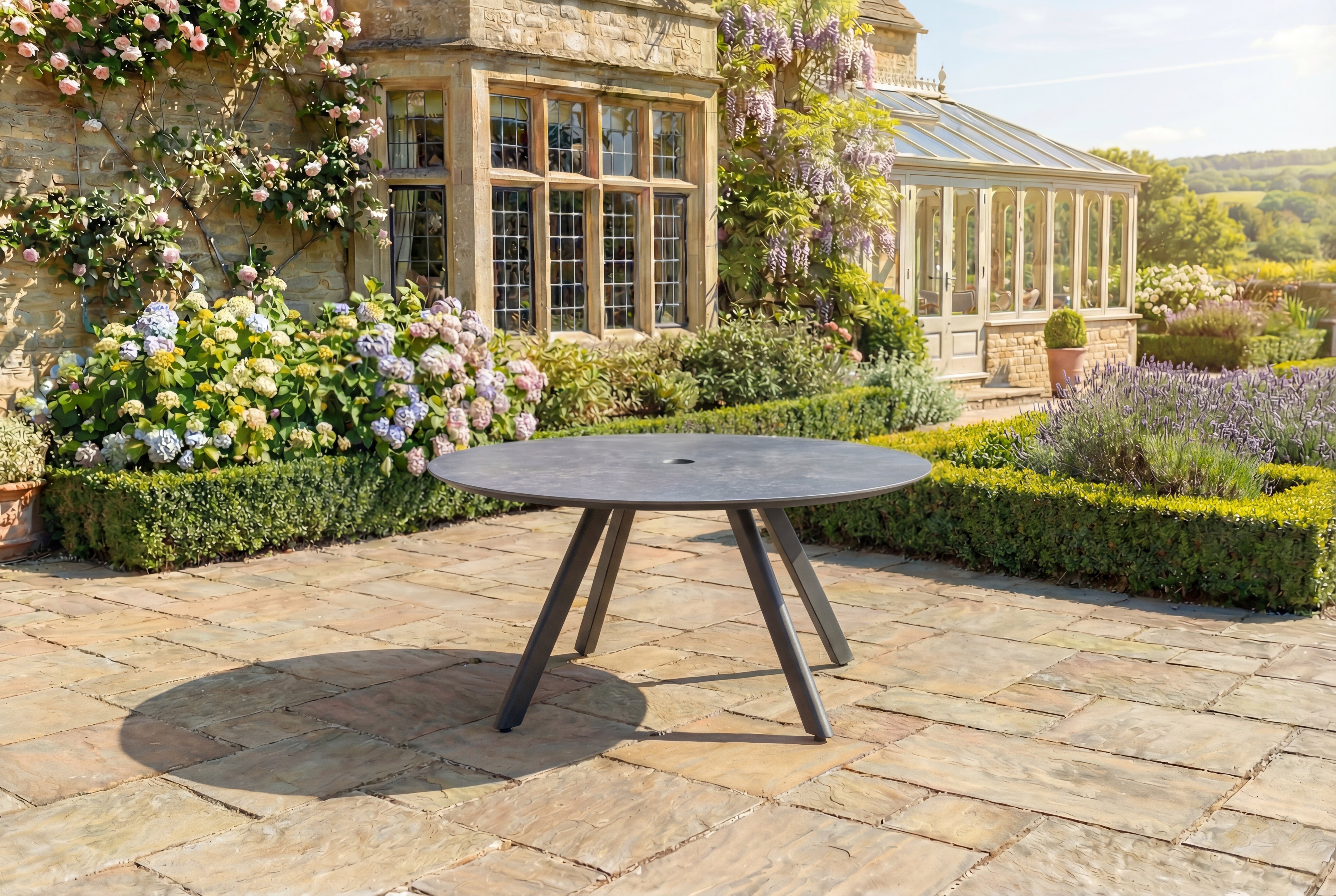 Round outdoor table on a stone patio with floral and garden background