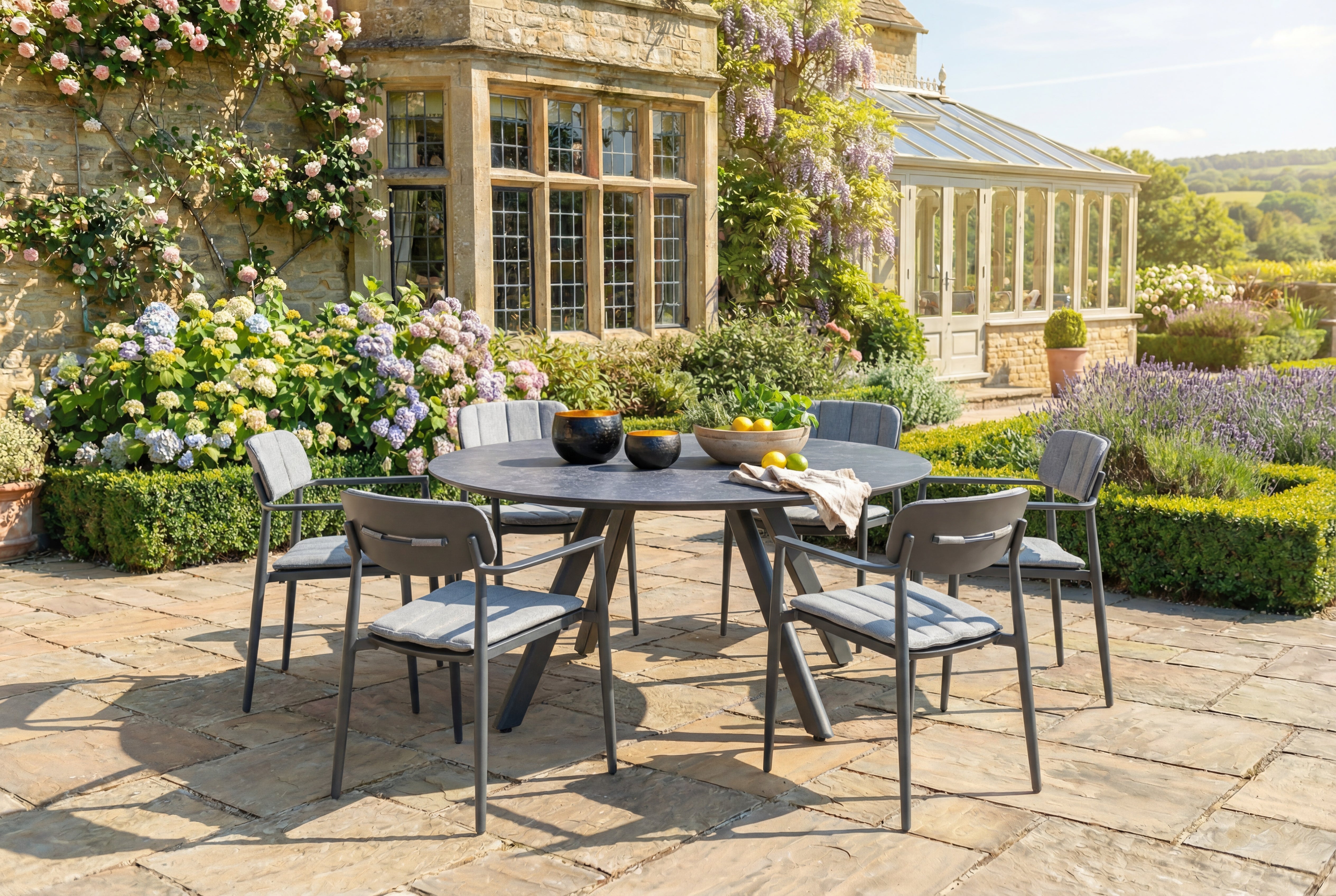 Outdoor patio set with round dining table and chairs in a garden setting