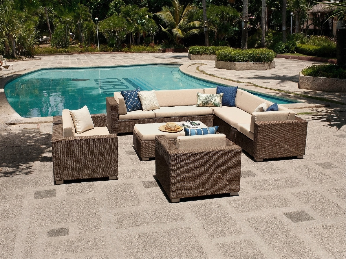 Luxury rattan outdoor patio furniture set by a pool with decorative pillows.