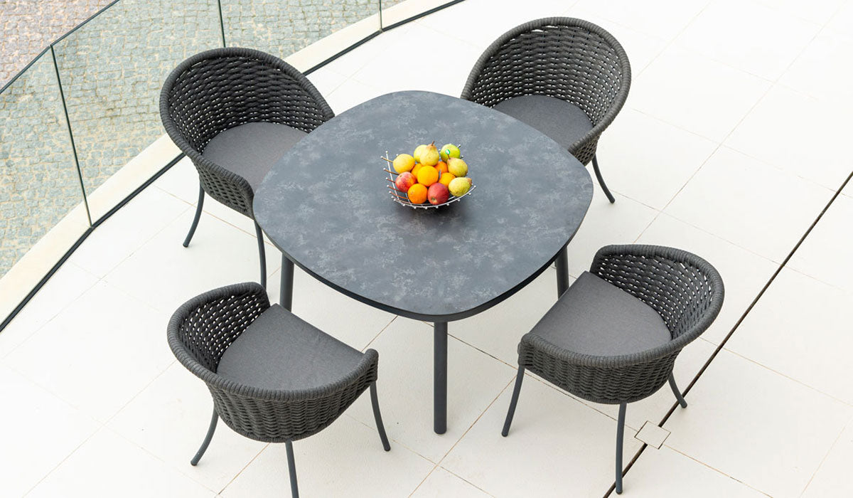 Round outdoor table with four chairs on a patio