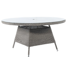 Round outdoor dining table with wicker frame and glass top on a white background