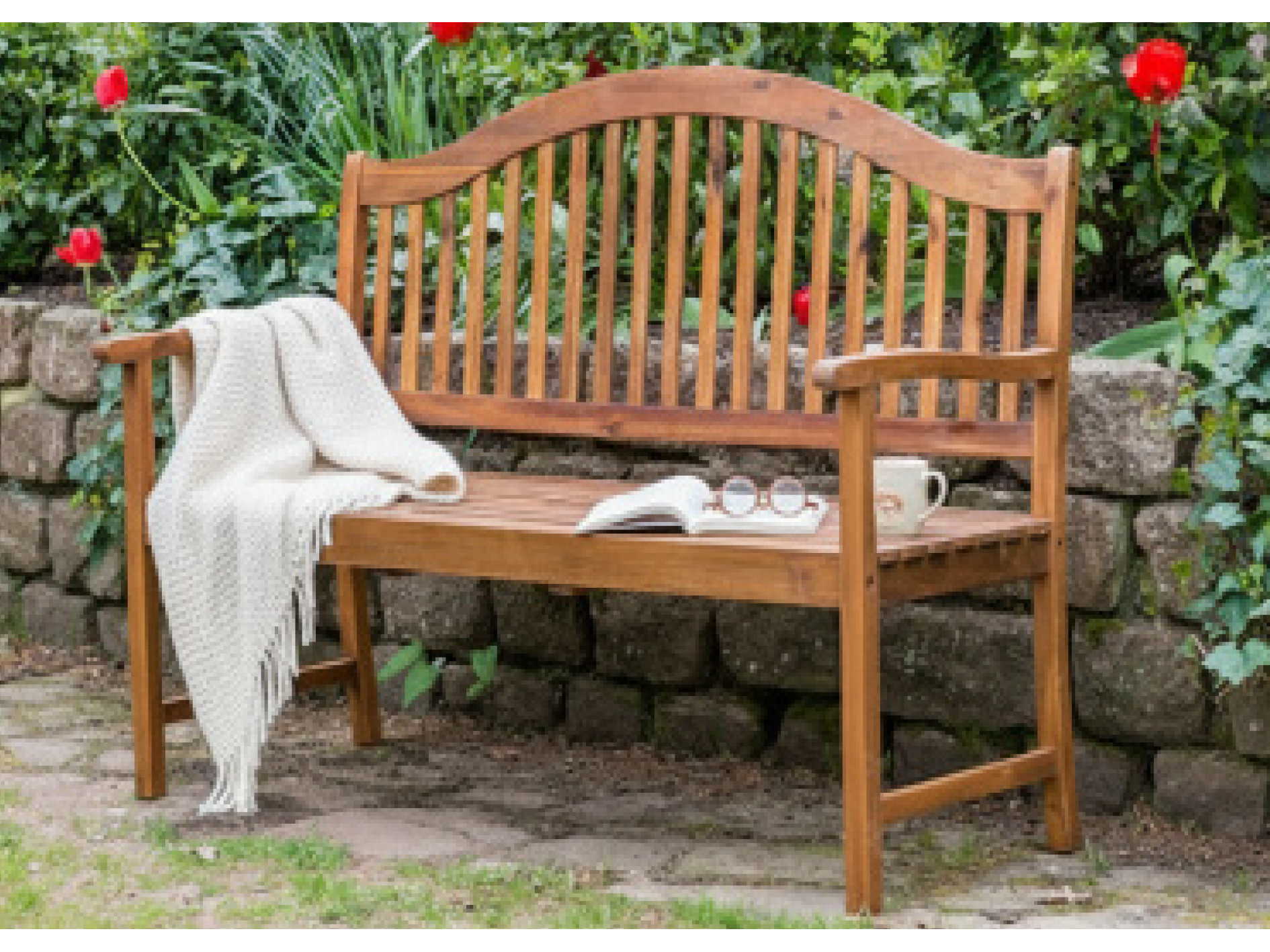 Wooden bench with a blanket and mug in a garden setting