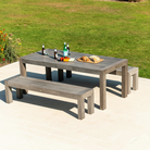 Old England table and benches in a patio setting overlooking green grass 