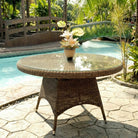 Luxury rattan table with a decorative plant by a poolside
