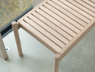 Looking down on the detail of the slatted indoor bench of light oak